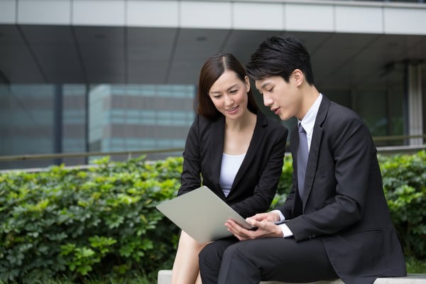 Businessman read on notebook computer with businesswoman